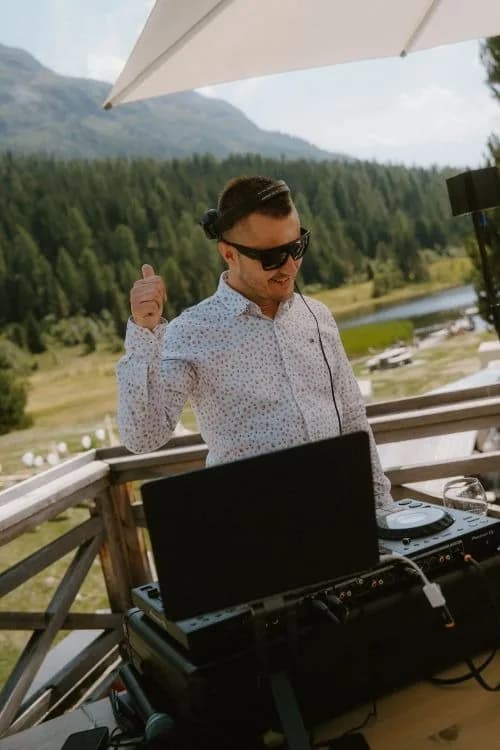 DJ Canis legt mit Kopfhörern an seinem Mischpult auf einer Terrasse auf