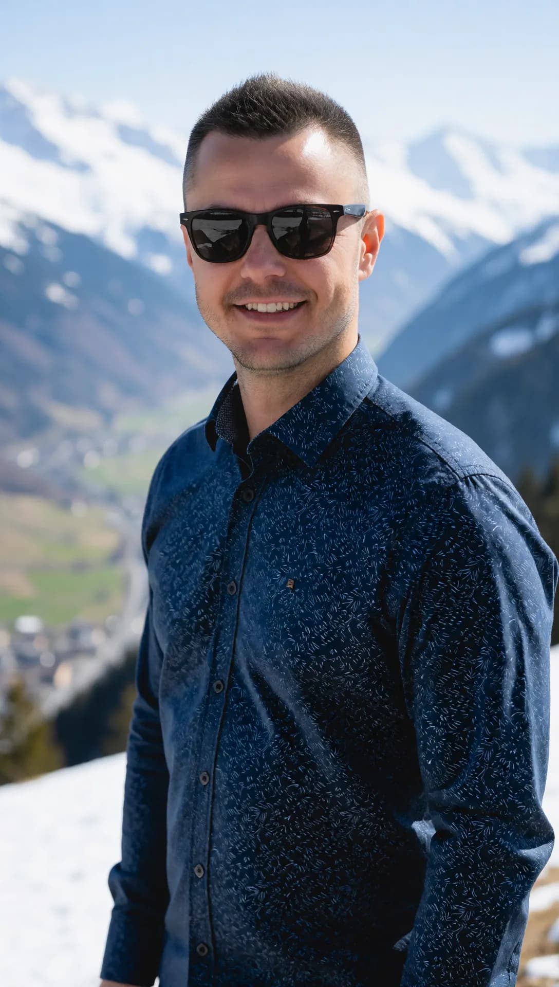 DJ Canis mit Sonnenbrille vor verschneiten Bergen
