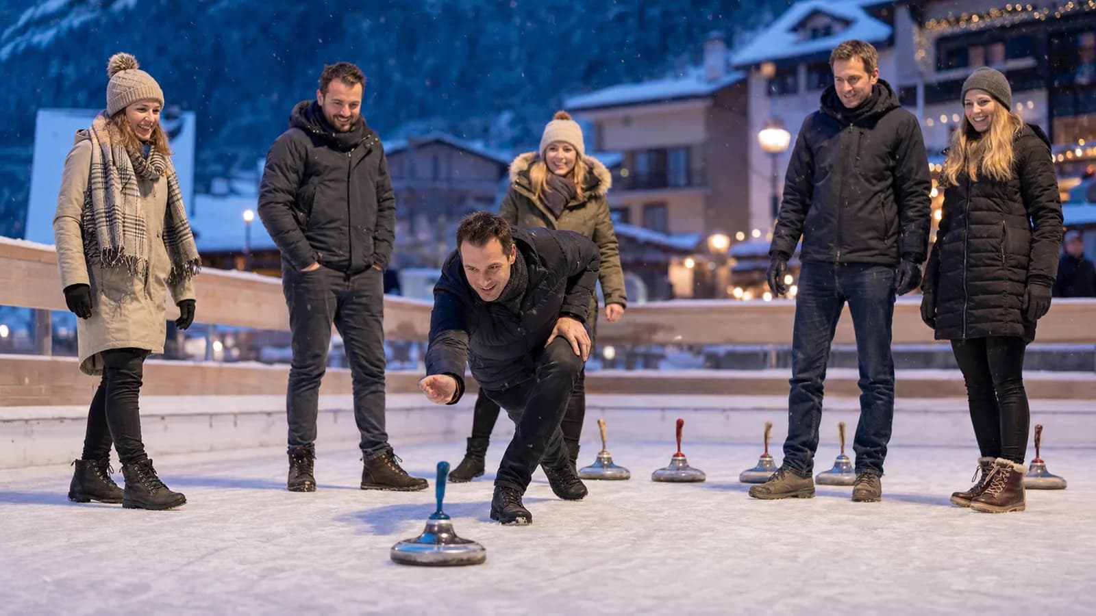 Kolleginnen und Kollegen beim Eisstockschiessen an einem winterlichen Firmenanlass